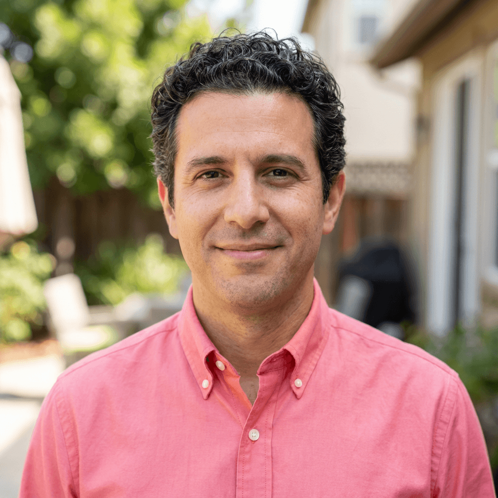 Male homeowner in his late 30s, Hispanic, smiling outdoors on a residential construction site